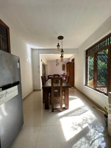 eine Küche und ein Esszimmer mit einem Tisch und einem Fenster in der Unterkunft Ambulugala Home Stay in Gampola