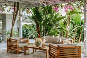 un patio con sofá, sillas y plantas en Nissi Park Hotel, en Ayia Napa