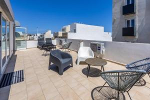 a balcony with chairs and tables on a building at Hard to come by - modern & huge house in Sliema in Sliema