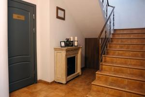 a hallway with a staircase with a fireplace and a door at Summit Villa in Chişinău