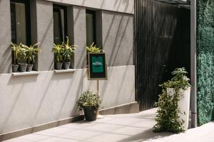 a sign on the side of a building with potted plants at Summit Villa in Chişinău