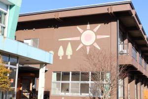 a building with a mural on the side of it at ゲストハウスあさひのお宿 in Kurodahara