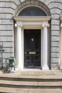 czarne drzwi wejściowe budynku z kolumnami w obiekcie Albany House w Dublinie