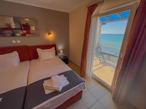 a bedroom with a bed and a view of the ocean at Studios Plaka in Skala Kallirachis