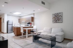 uma cozinha e sala de estar com um sofá e uma mesa em ALH VAcay - Sulafa Tower - 1 Bedroom em Dubai
