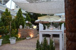a patio with an umbrella and a table in a garden at Nikos Apartments in Stalís