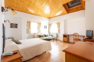Hotel Conde De Badaran في Badarán: غرفة نوم مع سرير وغرفة معيشة