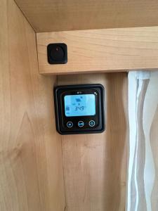 an electronic device is embedded in a wooden cabinet at Комфортный семейный автодом на 5 человек in Tbilisi City