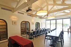 - une salle à manger avec des tables, des chaises et des fenêtres dans l'établissement Golfe Hotel, à Porto-Vecchio