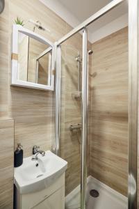 a bathroom with a sink and a shower at 29 Avenue Apartments in Kraków