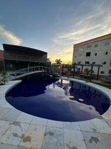 una gran piscina de agua frente a un edificio en Flat Alter do chão - Ilha bela Residence en Alter do Chao