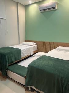 um quarto de hospital com duas camas e ar condicionado em Flat Alter do chão - Ilha bela Residence em Alter do Chão