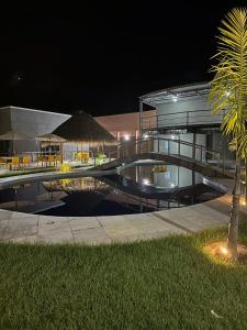 a building with a swimming pool at night at Flat Alter do chão - Ilha bela Residence in Alter do Chao