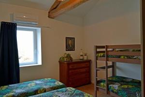 a bedroom with two bunk beds and a window at La Magnanerie de l'Estrade, gîte 8 pers avec piscine in Rosières