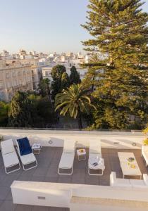 Blick auf eine Terrasse mit Liegestühlen und einem Baum in der Unterkunft Candelaria10 in Cádiz