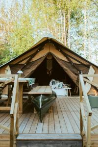 une tente avec une table et un banc sur une terrasse dans l'établissement The Mangevie, à Furudal