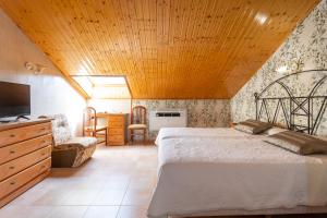 a bedroom with a large bed with a wooden ceiling at Hotel Conde De Badaran in Badarán