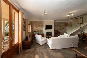 ein Wohnzimmer mit weißen Möbeln und einer Treppe in der Unterkunft Eco Finca Can Alegria with Pool in Llucmajor