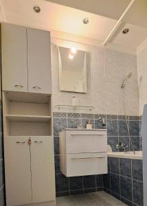 uma casa de banho branca com um lavatório e um espelho em Lovely furnished 1 bedroom flat with balcony in Ostrava em Hrabŭvka