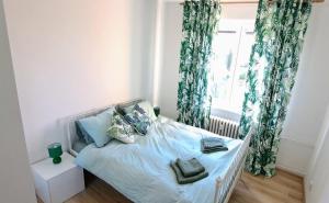 um quarto com uma cama com almofadas azuis e uma janela em Lovely furnished 1 bedroom flat with balcony in Ostrava em Hrabŭvka