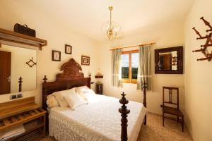 Eco Finca Can Alegria with Pool - Happy Rentals في لوكماجور: غرفة نوم بها سرير كبير وثريا +27 صورة