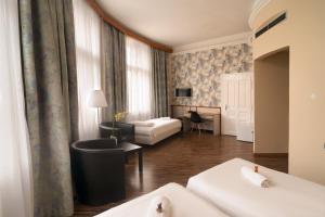 Habitación de hotel con cama y sala de estar. en Korona Hotel en Nyíregyháza