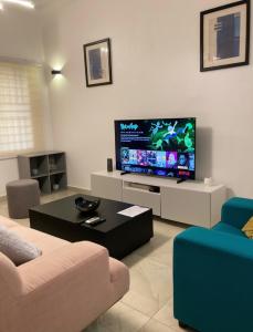a living room with a large flat screen tv at LUXURYs apartment in Abomey-Calavi