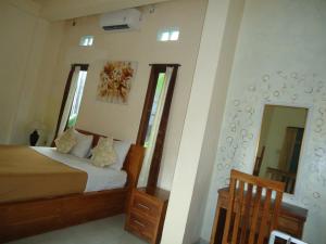 1 dormitorio con 1 cama y 2 espejos en Kenari House, en Ubud