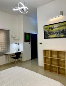 a bedroom with a bed and a desk and a tv on the wall at LUXURYs apartment in Abomey-Calavi