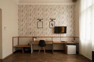 尼賴吉哈佐的住宿－卡羅納酒店，一张桌子,一张桌子,一台电脑和一把椅子放在一个房间里