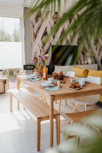 einen Holztisch mit Essen darauf im Wohnzimmer in der Unterkunft La villa des dunes, 100 m de la mer, spa, sauna in Ploudalmézeau