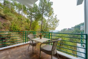 a balcony with two chairs and a table with a view at The Kasauli Walk !! Top Rated & Most Awarded Property in Kasauli in Kasauli
