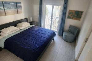 a bedroom with a blue bed and a chair at Sunset Cove - Condo 314 in George Town +21 photos