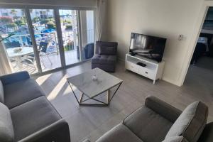 a living room with a couch and a tv and a table at Sunset Cove - Condo 314 in George Town