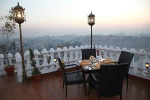a table and chairs on a balcony with a view at Fort Continental Hotel in Peshawar