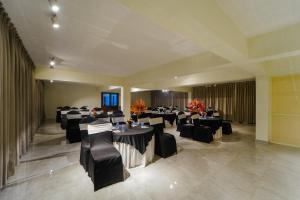 une salle de banquet avec des tables noires et des chaises noires dans l'établissement The Kasauli Walk !! Top Rated & Most Awarded Property in Kasauli, à Kasauli
