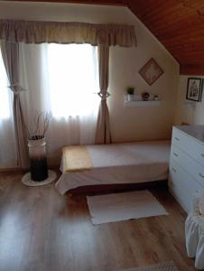 a bedroom with a bed and a large window at Nóra Vendégház in Abádszalók +36 photos