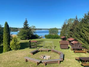 a park with picnic tables and a fire pit at Hotelik Zełwągi in Mikołajki
