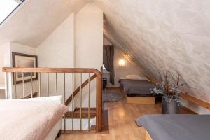 a attic room with a staircase and a bed at Preila Kristima-3 in Preila