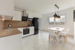 a kitchen and dining room with a table and chairs at Bright Apartment in Koper