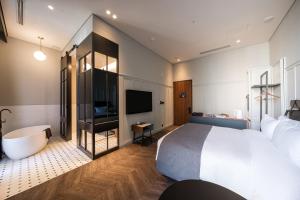 a hotel room with a large bed and a television at Junibino Hotel Hongdae in Seoul