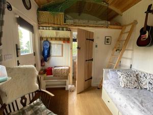a small room with a bunk bed and a ladder at Beautiful Shepherd's Hut - Lois Weedon in Weston