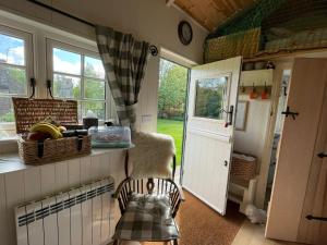 a kitchen with a door and a basket of food at Beautiful Shepherd's Hut - Lois Weedon in Weston