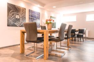 a dining room with a wooden table and chairs at Remstal Hotel in Weinstadt