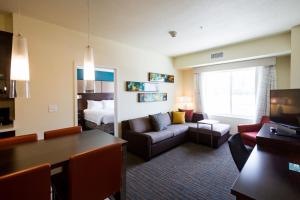 Habitación de hotel con cama y sala de estar. en Residence Inn by Marriott Oklahoma City Northwest en Oklahoma City