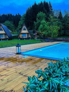 een tuin met een zwembad en een huis bij Catunul din Podei A-Frame in Dragoslavele