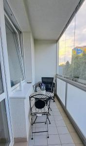 uma varanda com uma mesa, uma cadeira e uma janela em Lovely furnished 1 bedroom flat with balcony in Ostrava em Hrabŭvka