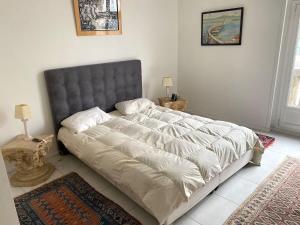 ein Schlafzimmer mit einem großen Bett mit einem grauen Kopfteil in der Unterkunft Appartement Opera Chauchat CityCosy in Paris