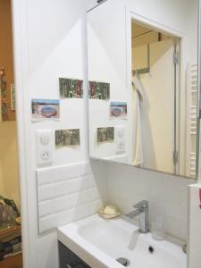 a white bathroom with a sink and a mirror at Appt Letort CityCosy in Paris