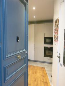 a blue door in a room with a kitchen at Appt Letort CityCosy in Paris
